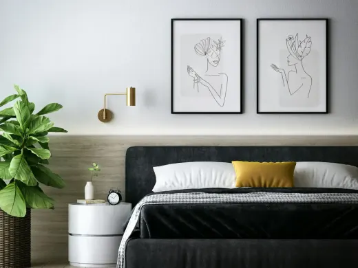 Schlafzimmer mit dunkler Akzentwand und Kunstdrucken